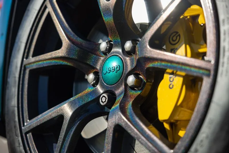 Wheel with a yellow brake caliper and teal center cap