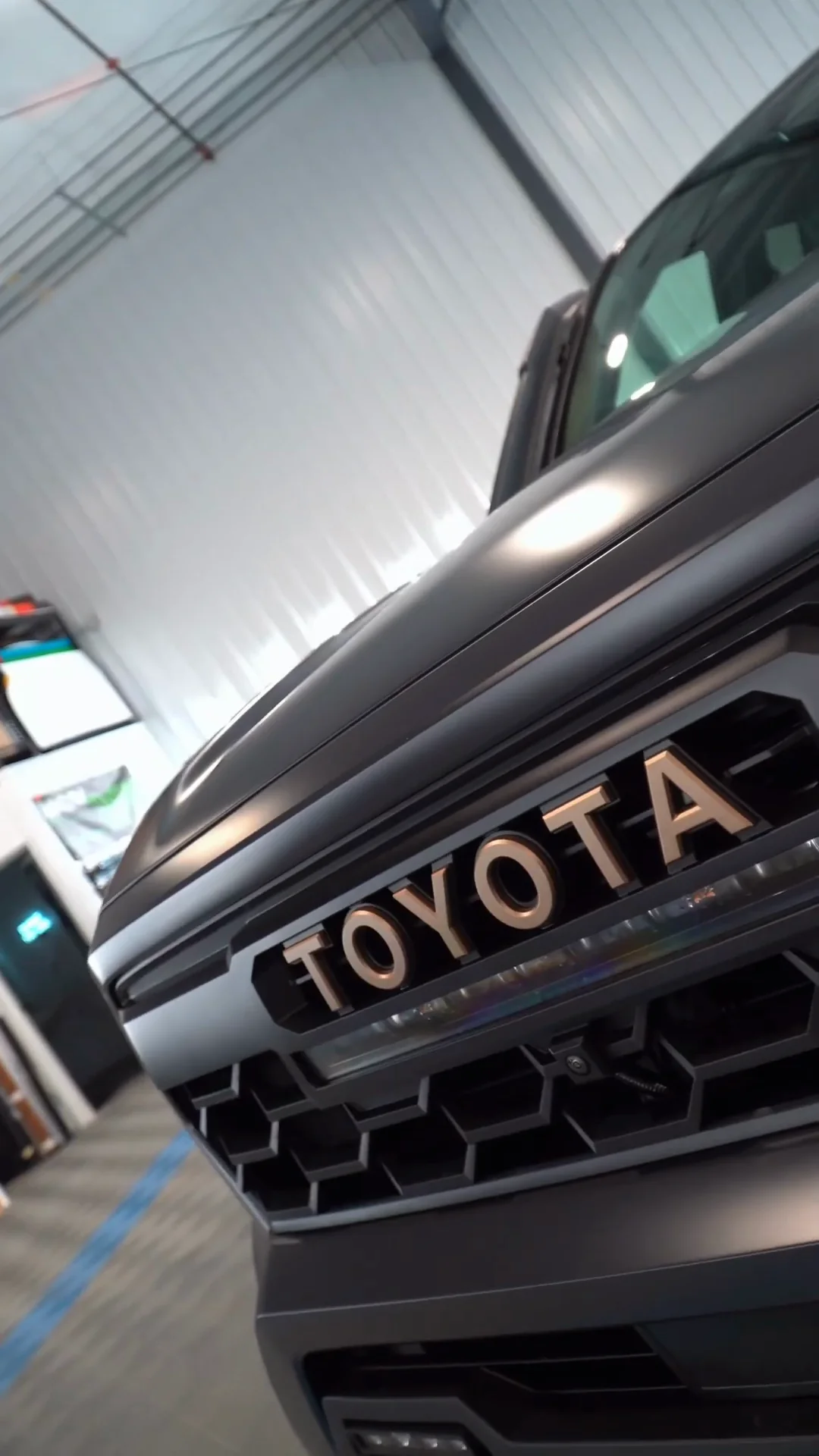 TOYOTA lettering on the matte gray grille of a Tacoma