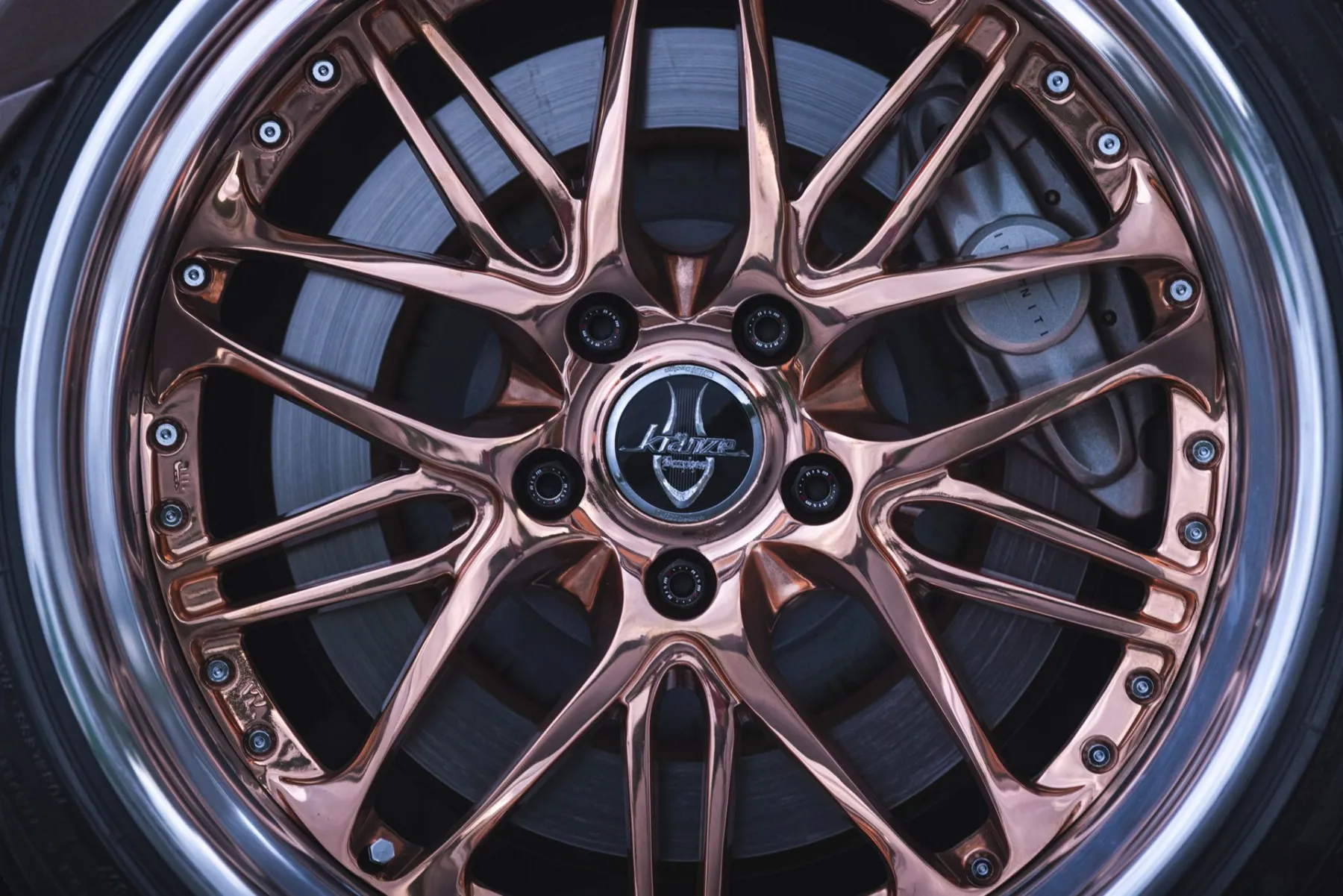 Close-up of a rose-gold chrome multi-spoke wheel with a polished outer lip