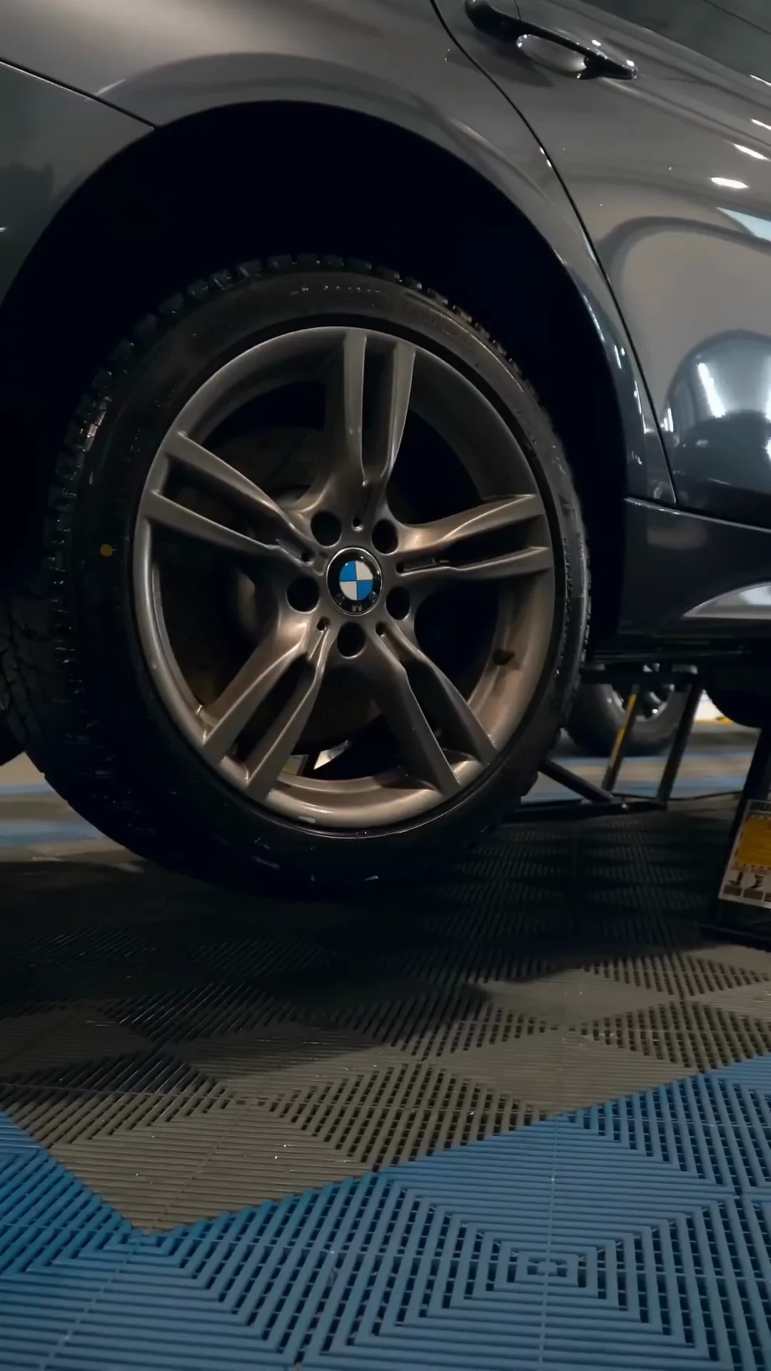 Wheel on a gray BMW in the shop bay
