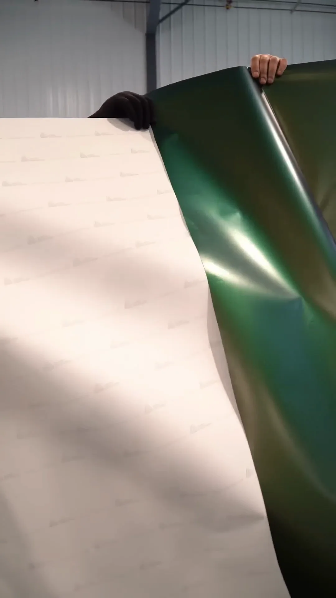 Sheet of green color-shift wrap film unrolled in the shop
