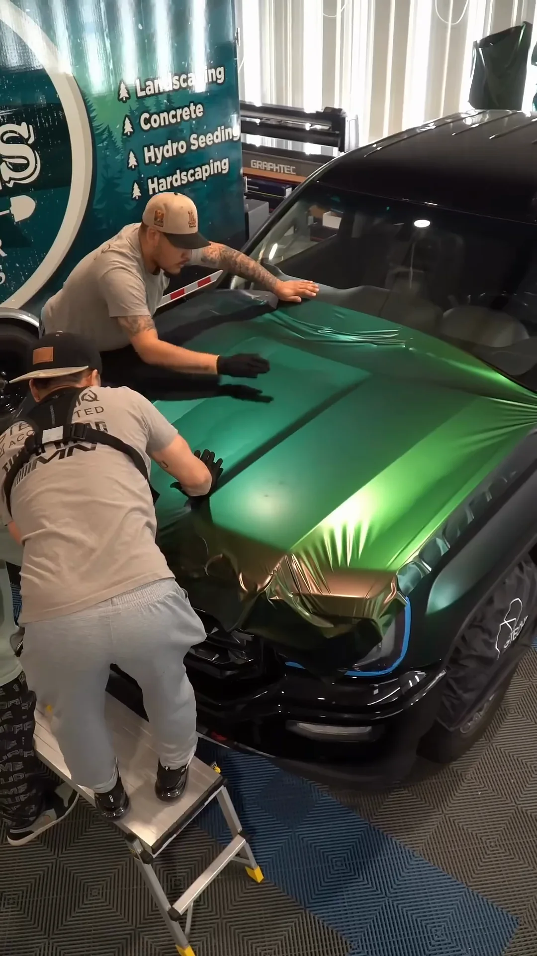 Two installers wrapping the hood of a GMC Sierra