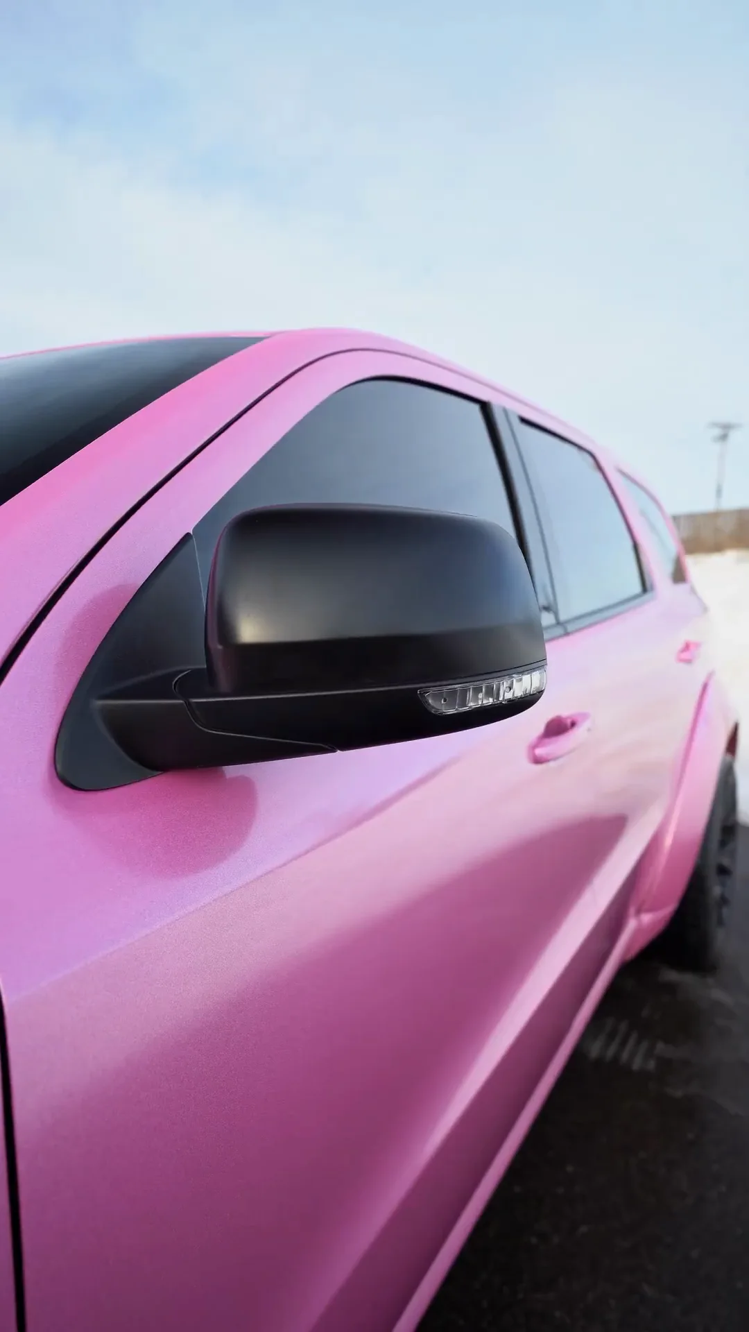 Mirror and fender of a Dodge Durango wrapped in pink gloss