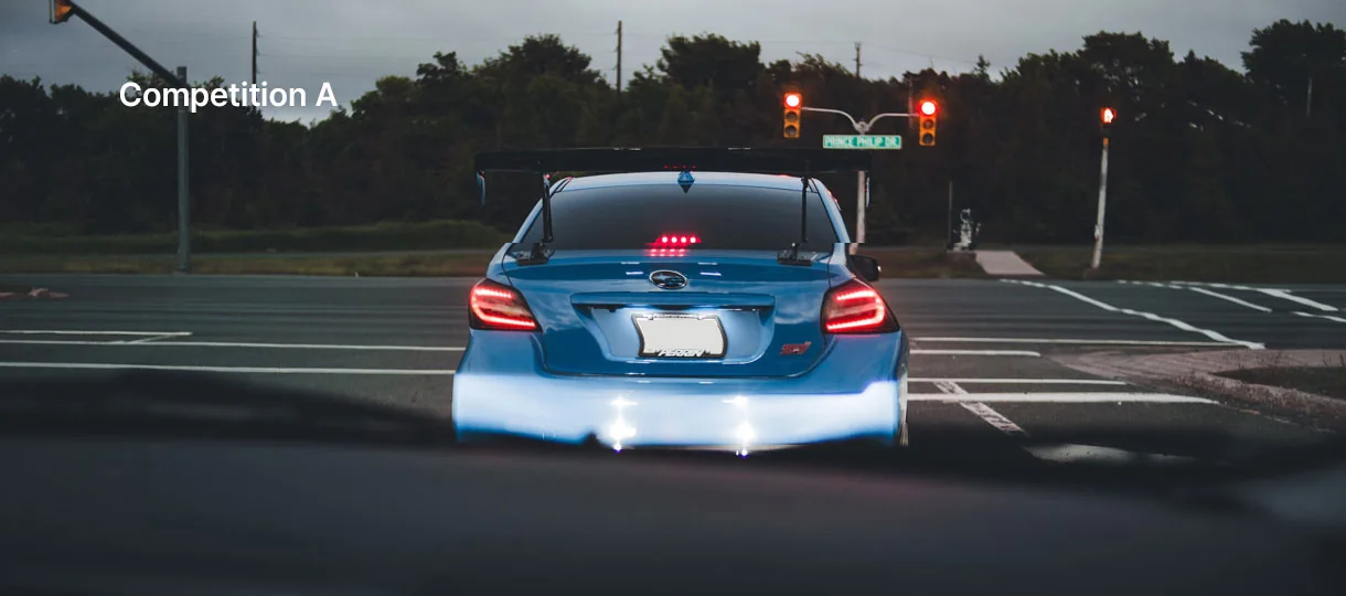 A driver’s view at dusk of a blue Subaru WRX STI, its outline warped by the windshield film
