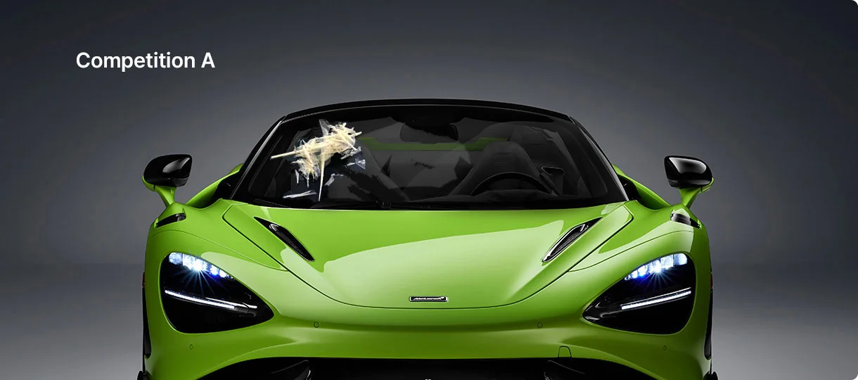 A green McLaren with a torn, yellowed clump of film and adhesive stuck to its windshield